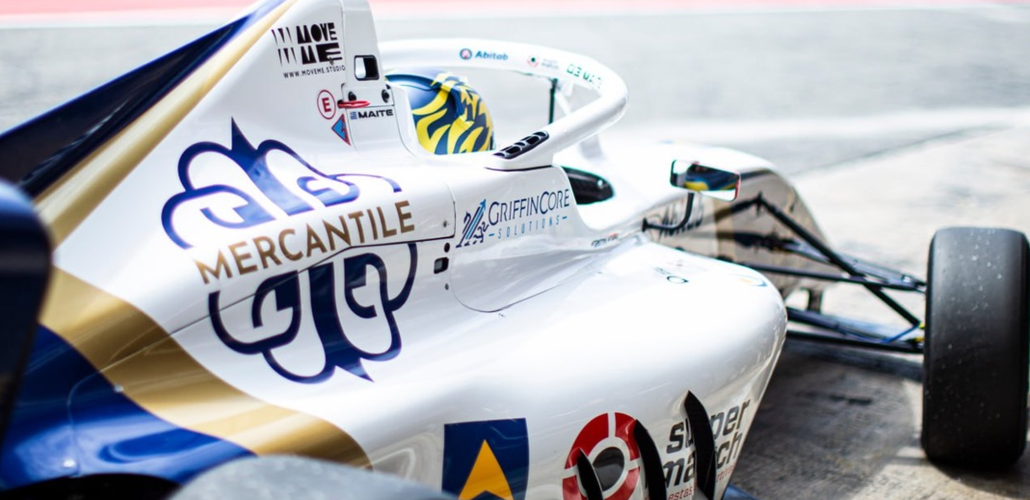 Close-up of a Mercantile-branded F4 race car in white, navy, and gold.
