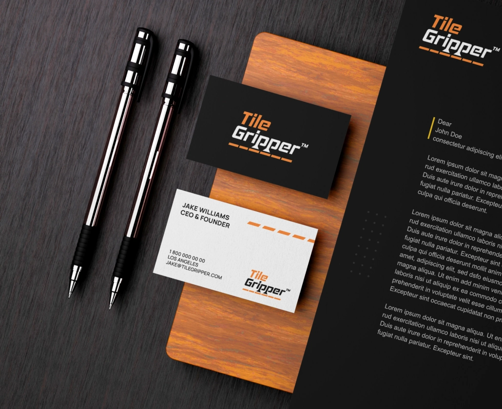 Tile Gripper business cards and stationery on a wooden desk.